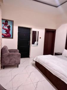 a bedroom with a bed and a chair and a window at Enseno Hotel in Karshi