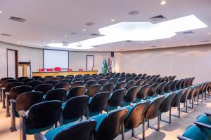 an empty lecture hall with chairs and a screen at Hotel Aojesp in Caraguatatuba +64 photos