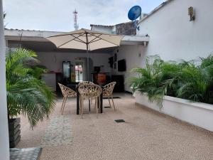 a table and chairs under an umbrella on a patio at Hotel Los Potrillos in Aguazul
