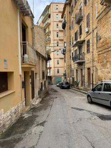 an alley with cars parked on the sides of buildings at b&b centro città in Agrigento