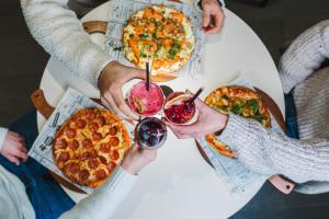 a group of people sitting at a table with pizzas at Wilderness Hotel Kieppi in Saariselka