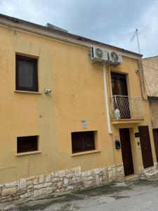 a yellow building with three windows and a balcony at b&b centro città in Agrigento +10 photos