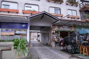 a shop with a horse statue in front of a building at Hospedagem Vila Suiça Centro in Gramado