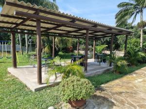 a wooden pergola with tables and plants in a yard at Boskraai Self-Catering -74 Hornbill Street in St Lucia