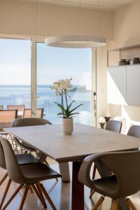 a dining room table with chairs and a vase with flowers at Villa Eze Vue Mer in Éze