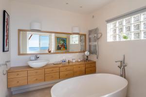 a bathroom with a white tub and a sink at Villa Eze Vue Mer in Éze +75 photos