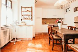 a kitchen and dining room with a wooden table and chairs at La casa di Solcio - Lakeside srl L&B in Lesa