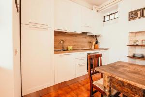 a kitchen with white cabinets and a wooden table at La casa di Solcio - Lakeside srl L&B in Lesa
