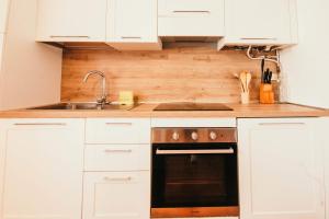 a kitchen with white cabinets and a sink and a stove at La casa di Solcio - Lakeside srl L&B in Lesa +15 photos