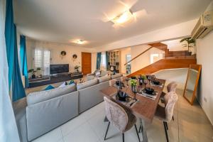 a living room with a couch and a table at Villa Stella with Jacuzzi in Oroklini