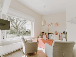 ein Wohnzimmer mit Tisch und Stühlen und einem Fenster in der Unterkunft Ostseeferien Evershof in Travemünde