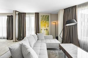 a living room with a white couch and a table at Dunetton - self check-in hotel in Klaipėda