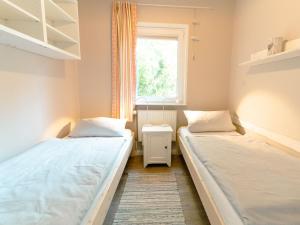 zwei Betten in einem kleinen Zimmer mit Fenster in der Unterkunft Ostseeferien Evershof in Travemünde