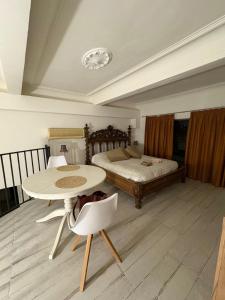 a bedroom with a bed and a table and chairs at Palazzo Bosco in Cosenza +3 photos