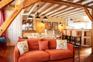 a living room with an orange couch and a kitchen at Appartements en centre ville à Châteauroux Indre in Châteauroux