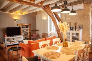 a living room with a table with chairs and a couch at Appartements en centre ville à Châteauroux Indre in Châteauroux