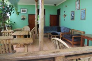a living room with wooden furniture and green walls at Kibale Eco-Home in Bigodi
