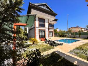 a house with a swimming pool in front of it at canyon villa in Kemer