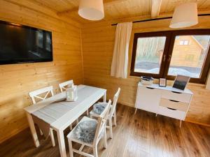a dining room with a table and chairs and a television at Domki w Lipnicy in Lipnica