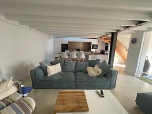 a living room with a couch and a kitchen at Arcachonnaise 5 chambres, 500M de la plage et 6 vélos à disposition in Arcachon