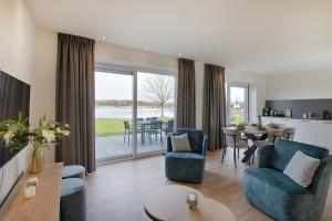 a living room with blue chairs and a table at Resort Boschmolenplas in Heel