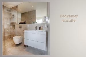 a bathroom with a white sink and a toilet at Resort Boschmolenplas in Heel +83 photos