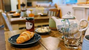 a table with a plate of croissant and a glass of water at South Downs Eco Lodge & Camping in East Meon