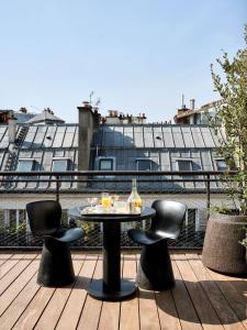 a table and chairs on a deck with a building at Bus Palladium in Paris