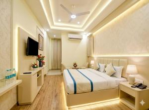 a hotel room with a bed and a television at Hotel Olive Aero Suites Near Delhi IGI Airport in New Delhi