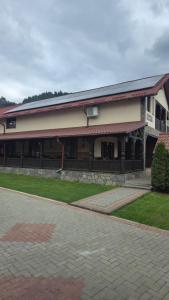 a building with a brick driveway in front of it at Pensiunea Rozalina in Rozavlea