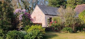 a small stone house with a garden and flowers at Gîte G175 in Grosville