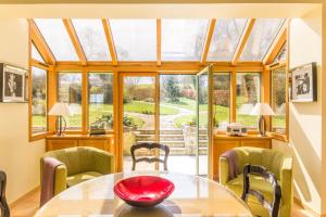a conservatory with a table and chairs and a window at Gîte G175 in Grosville +15 photos