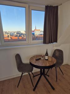 a table and two chairs in a room with windows at Studio At C in Zandvoort