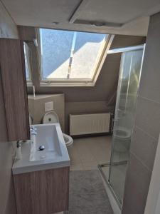 a bathroom with a toilet and a sink and a window at Studio At C in Zandvoort