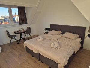 a large bed in a room with a table and chairs at Studio At C in Zandvoort