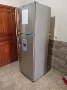 a stainless steel refrigerator in a kitchen next to a door at Apartamentos Centricos Puerto Iguazu in Puerto Iguazú