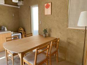 a dining room table and chairs in a kitchen at トシマトビ in Toshima
