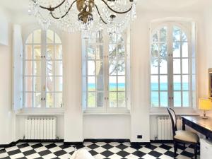 ein Kronleuchter in einem Zimmer mit Schreibtisch und Fenstern in der Unterkunft ALBA in Levanto
