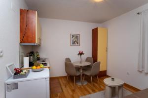 a kitchen with a table and chairs in a room at Villa Green Hema in Neum