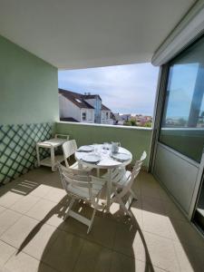 a white table and chairs on a balcony at Les flos bleus in La Bernerie-en-Retz