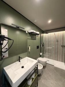 a bathroom with a white sink and a toilet at Lamal Hotel Napoli in Naples