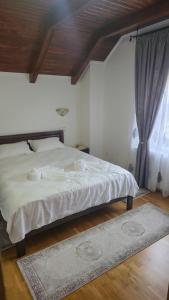 a bedroom with a large white bed and a window at Pensiunea Rozalina in Rozavlea +7 photos