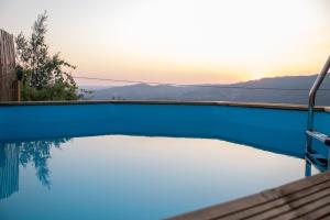a swimming pool with the sunset in the background at Casa de Sobreiros in Amarante