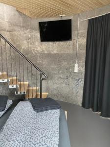a bedroom with a bed and a tv on a wall at Svalbarð guesthouse in Hvammstangi