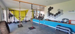 a gym with swings in a room with a pool at L'abri gascon in Auch