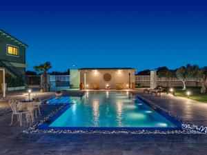 a swimming pool in a backyard at night at Villa Kika by holiday World in Ispica