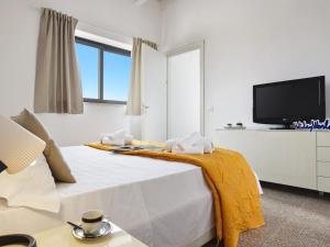 a white bedroom with a bed with a yellow blanket on it at Villa Kika by holiday World in Ispica