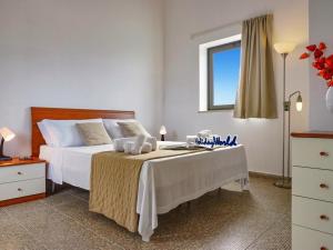 a bedroom with a bed with white sheets and a window at Villa Kika by holiday World in Ispica +22 photos