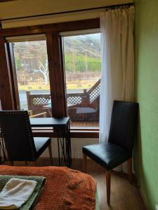 a room with a bed and two chairs and a window at Guest room with a mountain view in Laugarvatn