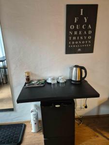 a black table with a tea kettle on top of it at Guest room with a mountain view in Laugarvatn